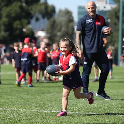 A girls running with the ball at a Demons Superclinic