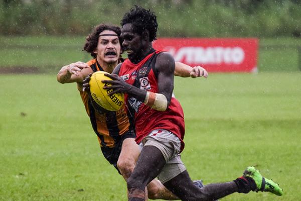 Nightcliff player about to tackle Tiwi player